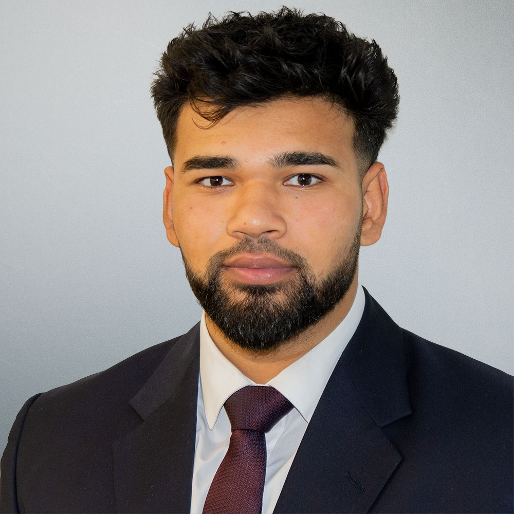 Trainee solicitor Moeez Iqbal smiling in a professional headshot at Flint Bishop.