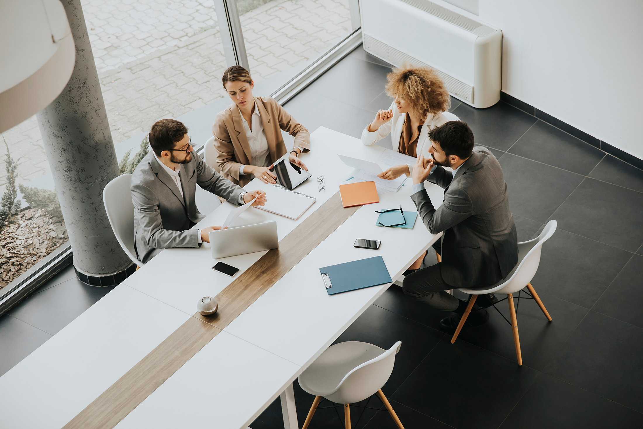 Employees and managers meeting around a table in a modern office discussing workplace and employment matters.