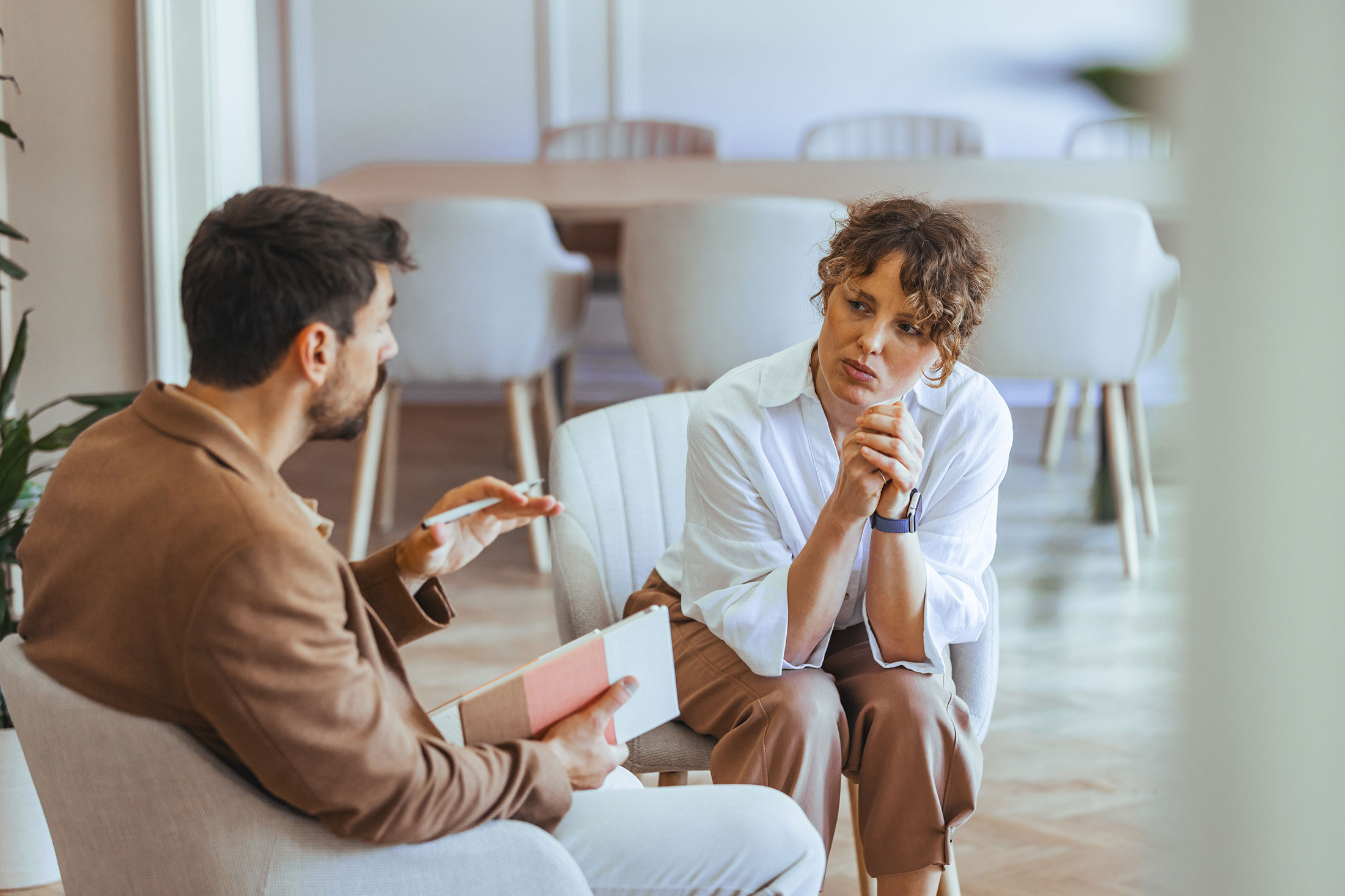 Man and woman having a serious workplace discussion in an open meeting area.